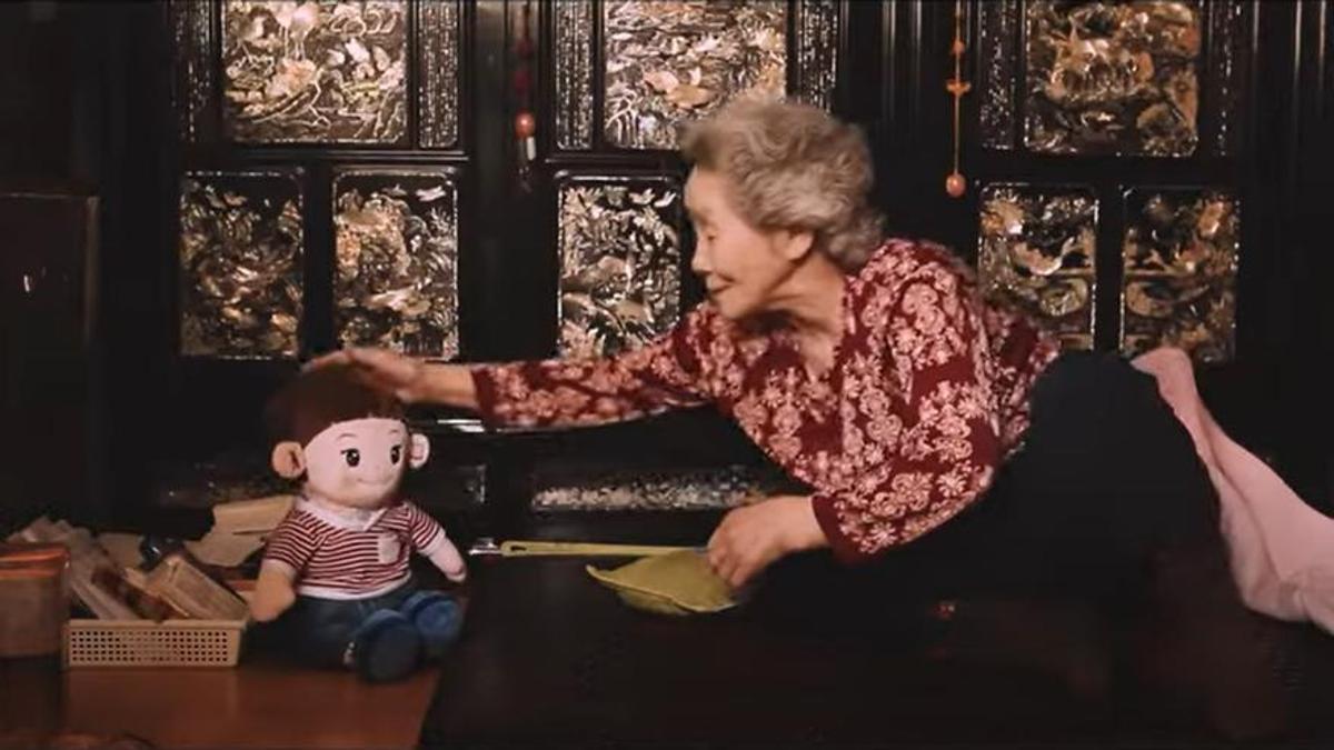 Una mujer mayor acaricia a su muñeco en un vídeo promocional.