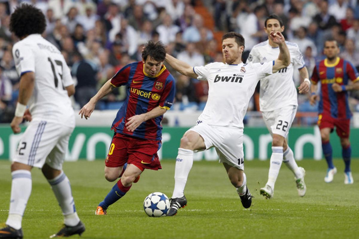 Leo Messi intenta superar l’entrada del centrecampista del Reial Madrid Xabi Alonso.