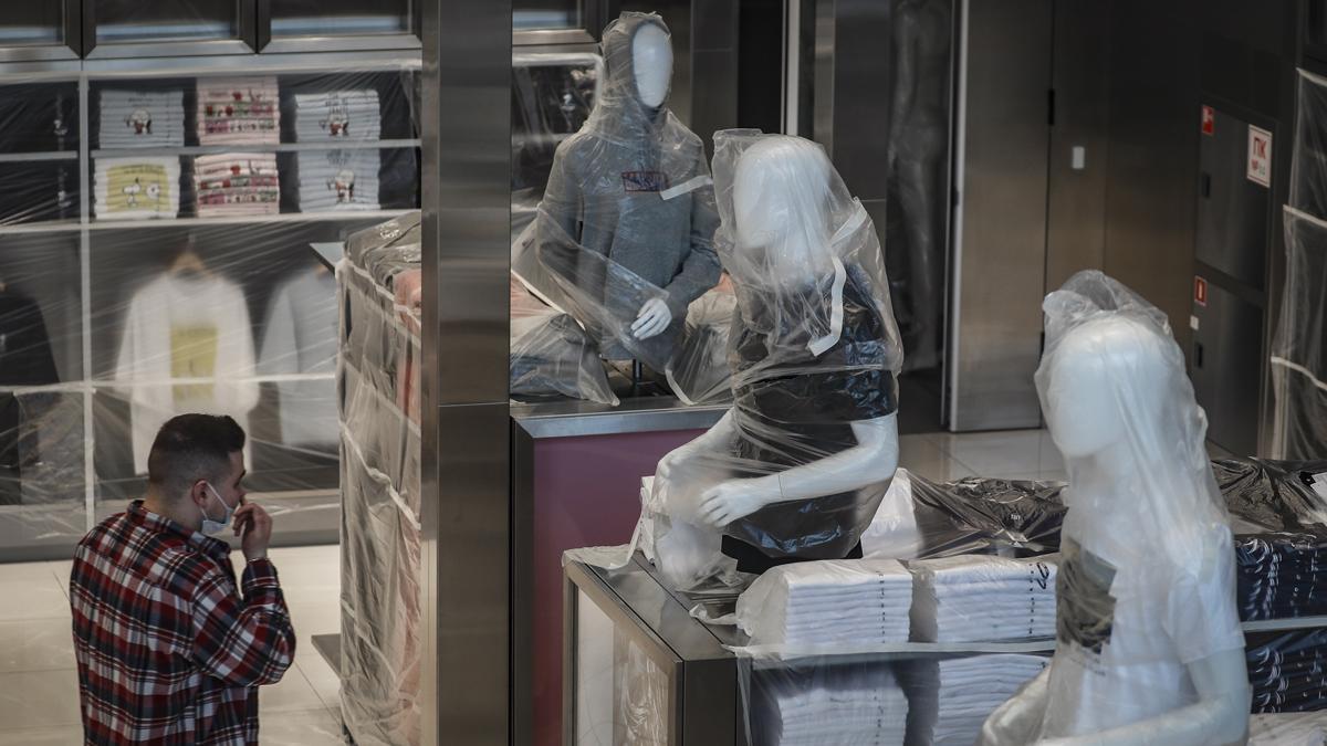 Un empleado mira maniquíes envueltos en plástico dentro de una tienda Uniqlo cerrada en Moscú, Rusia