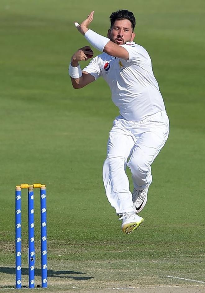 El paquistaní Yasir Shah (R) entrega el balón, durante el cuarto día del tercer y último partido de cricket de prueba entre Pakistán y Nueva Zelanda en el Sheikh Zayed International Cricket Stadium en Abu Dhabi.