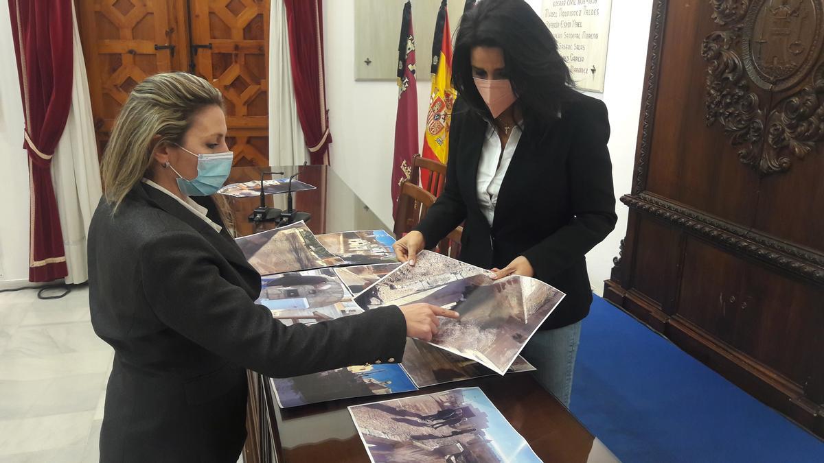 Las ediles populares María de las Huertas García y Mayte Martínez contemplan fotos del lugar.