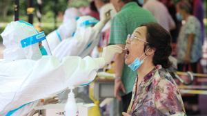 Un sanitario realiza una prueba diagnóstica de covid-19 en Nanjing, China.