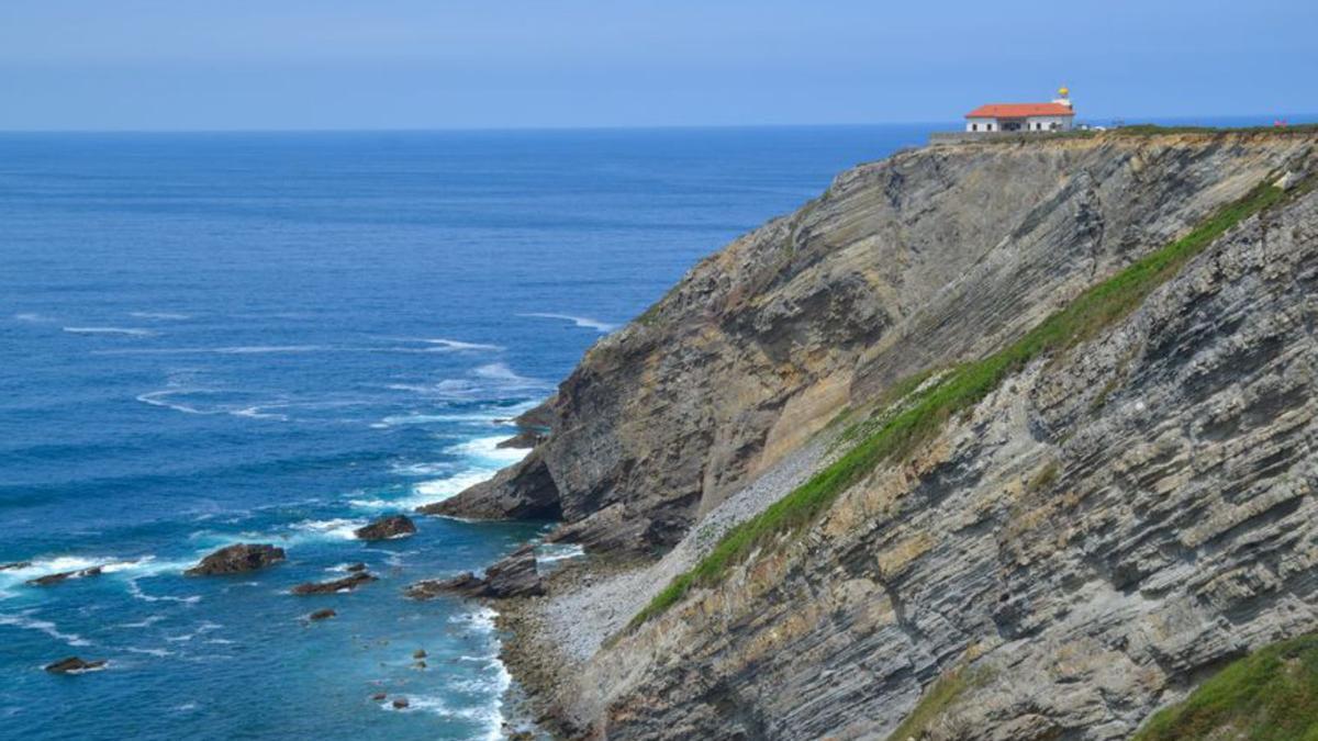 En el centro, el faro sobre el acantilado.