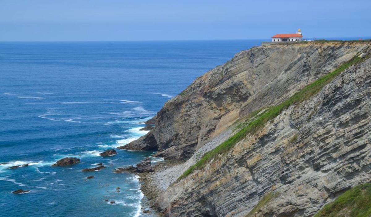 En el centro, el faro sobre el acantilado. Sobre estas  líneas, Juan Carlos Serra y Vese Taneva, en el mirador del cabo. | Ana Paz Paredes