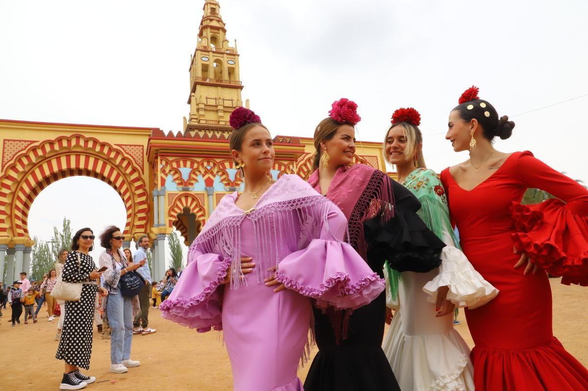 Cuatro mujeres se fotografían frente a la portada de la Feria.