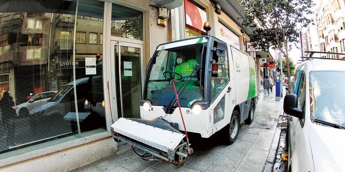 Un operario da empresa Urbaser traballa nunha acera do Ensanche compostelano