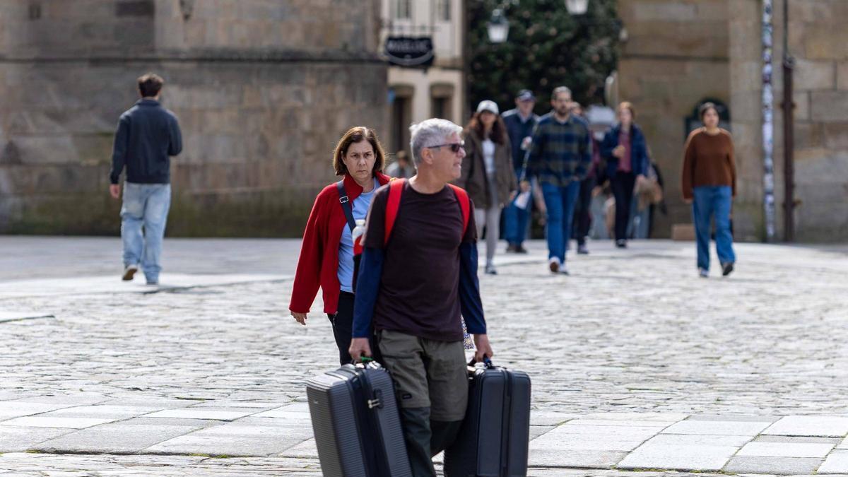 Turistas con maletas en la praza do Obradoiro el pasado puente de San José