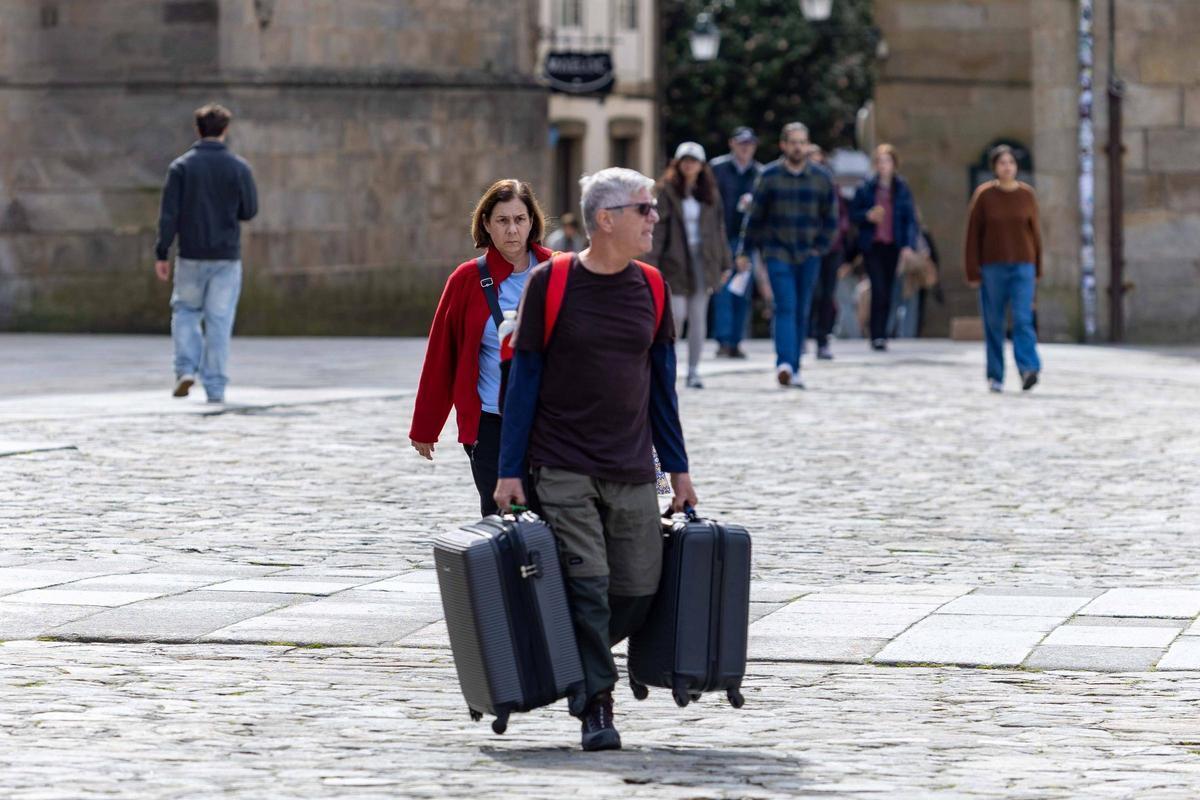 Turistas con maletas en la praza do Obradoiro el pasado puente de San José