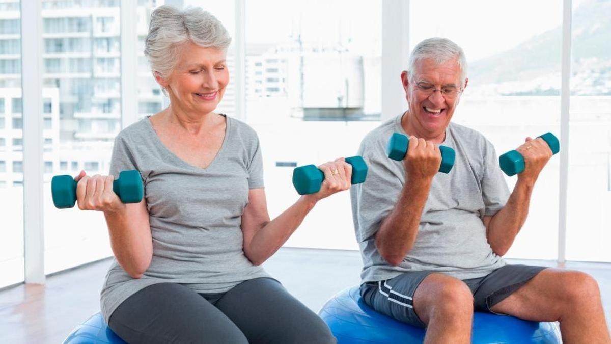 Grupo de personas de 60 años haciendo ejercicio de fuerza