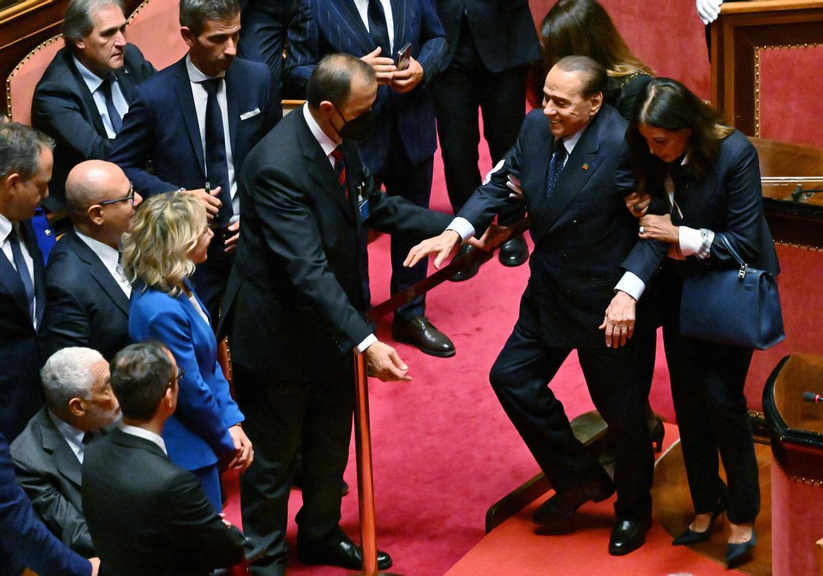 El líder de Forza Italia, Silvio Berlusconi, recibe ayuda durante su votación para elegir al nuevo presidente del Senado.