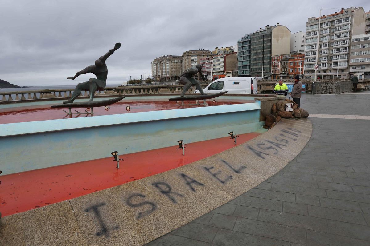 La fuente de los surfistas, con el agua teñida de rojo y una pintada contra Israel La fuente de los surfistas, con el agua teñida de rojo y una pintada contra Israel
