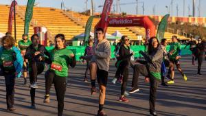 Unos corredores calientan antes participar en una edición anterior de la Carrera contra el Cáncer.