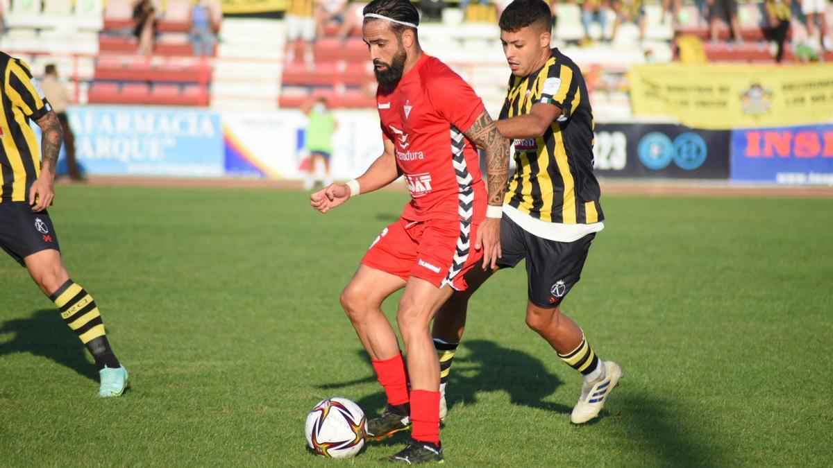 El centrocampista Manu Miquel protege el balón ante un jugador del San Roque de Lepe.