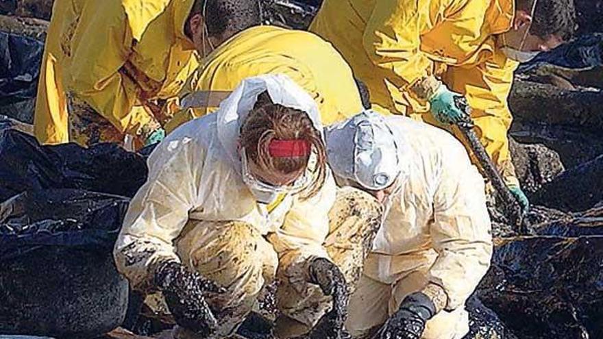 Voluntarios limpiando el fuel del ´Prestige´ en Ons en 2002.  // R. Grobas