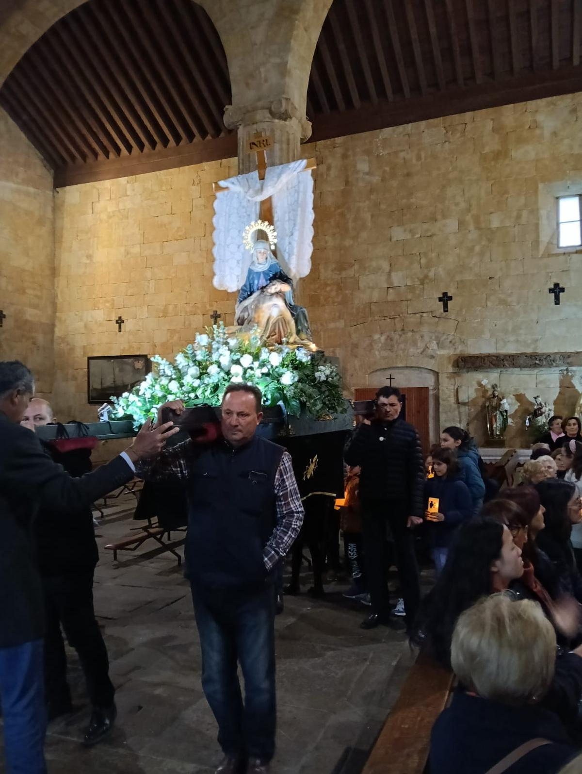 Varios cargadores portan la imagen de Nuestra Madre de Arcenillas en una procesión contenida en el templo por la lluvia.