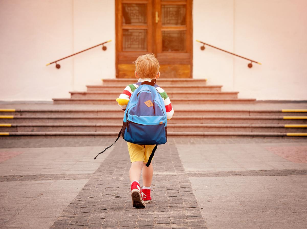 Un niño se dirige a su colegio en el primer día de vuelta a las clases.