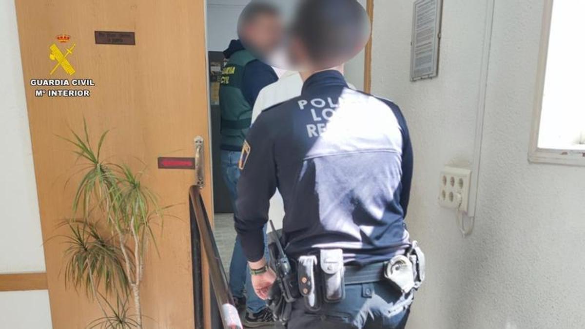 Traslado de uno de los detenidos por parte de la Guardia Civil y la Policía Local