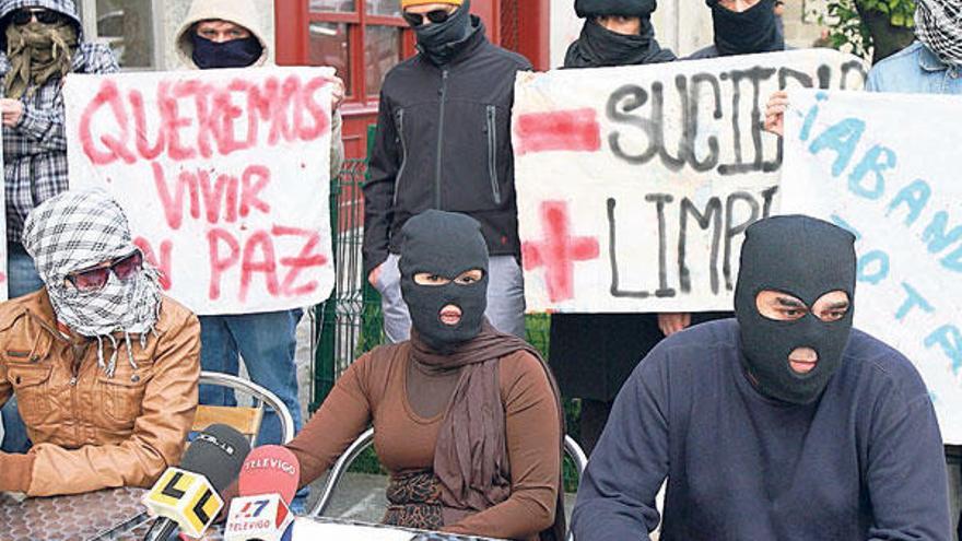 Miembros de la plataforma de afectados de la calle Eduardo Chao, ayer, con el rostro oculto durante la rueda de prensa. // J. de Arcos