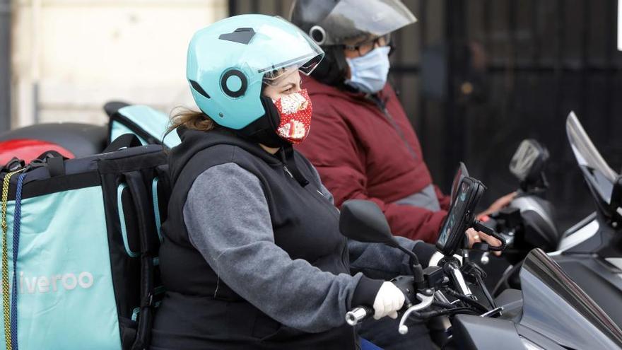 Dos &#039;riders&#039; de Deliveroo reparten con mascarillas.