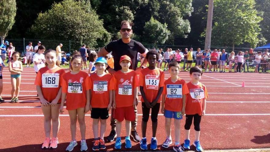 Uno de los entrenadores, Nacho Lacarra, junto a parte de los atletas de la escuela colunguesa.