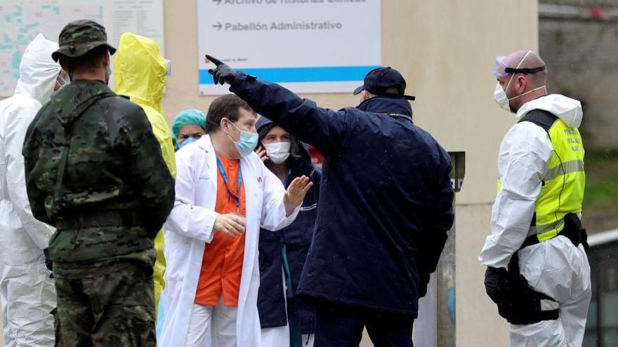 Sanitarios conversan con personal militar mientras trabajan en un hospital de campaÃ±a montado cerca del acceso de Urgencias del Hospital Gregorio MaraÃ±Ã³n.