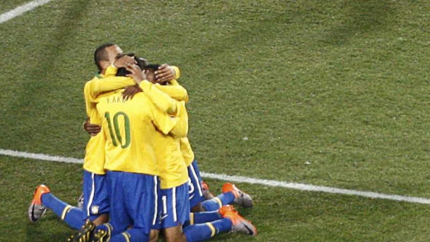 Los jugadores brasileños se abrazan tras el gol de Robinho.