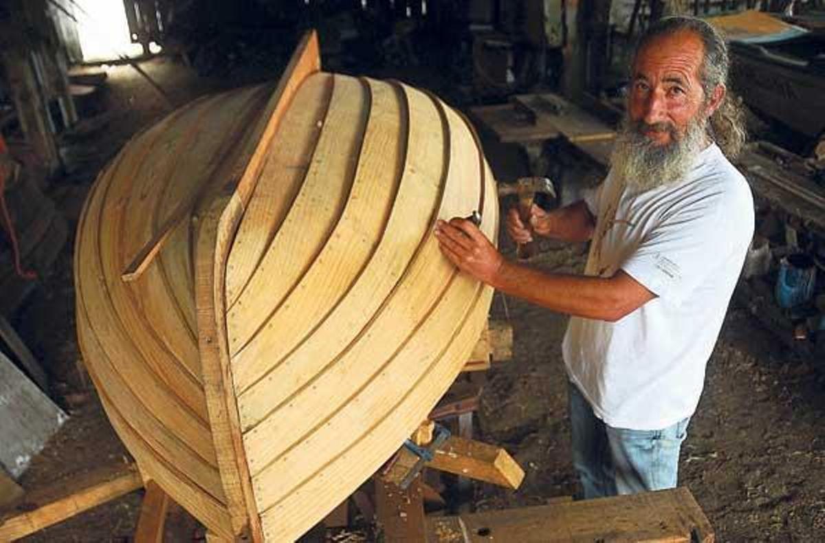 El presidente de Os Galos, Víctor Domínguez, con el barco, ayer en el astillero de Purro.  // G. Núñez