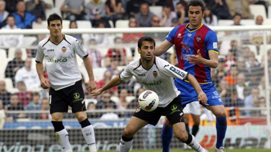 El centrocampista del Levante UD Vicente Iborra (d) trata de llevarse el balón ante los jugadores del Valencia CF Aritz Aduriz (i) y el brasileño Jonas Gon Alves.