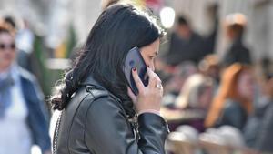 Una mujer atiende una llamada de teléfono en la calle.