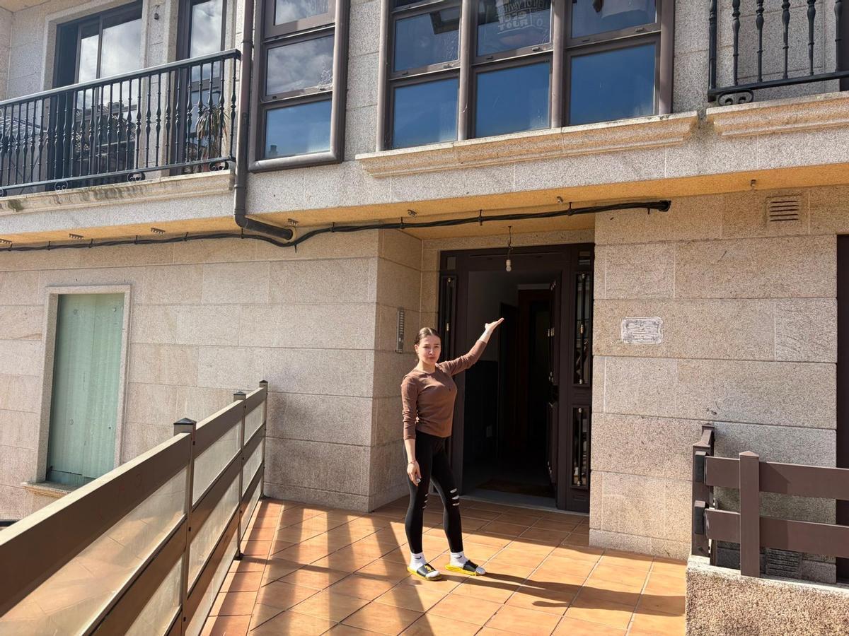 Carolina Martínez ante el portal del edificio de la travesía do Pedregal.