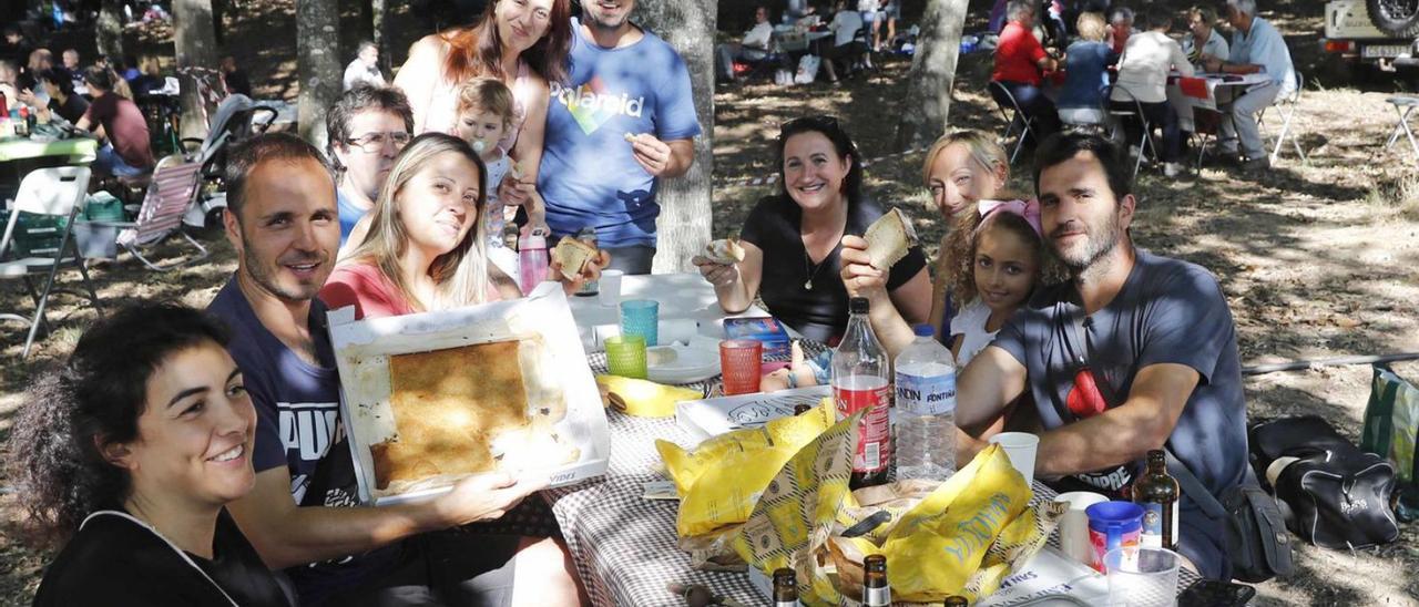 Varias personas posan con su comida en la “Romaría do Pan de Millo de Cabral”.