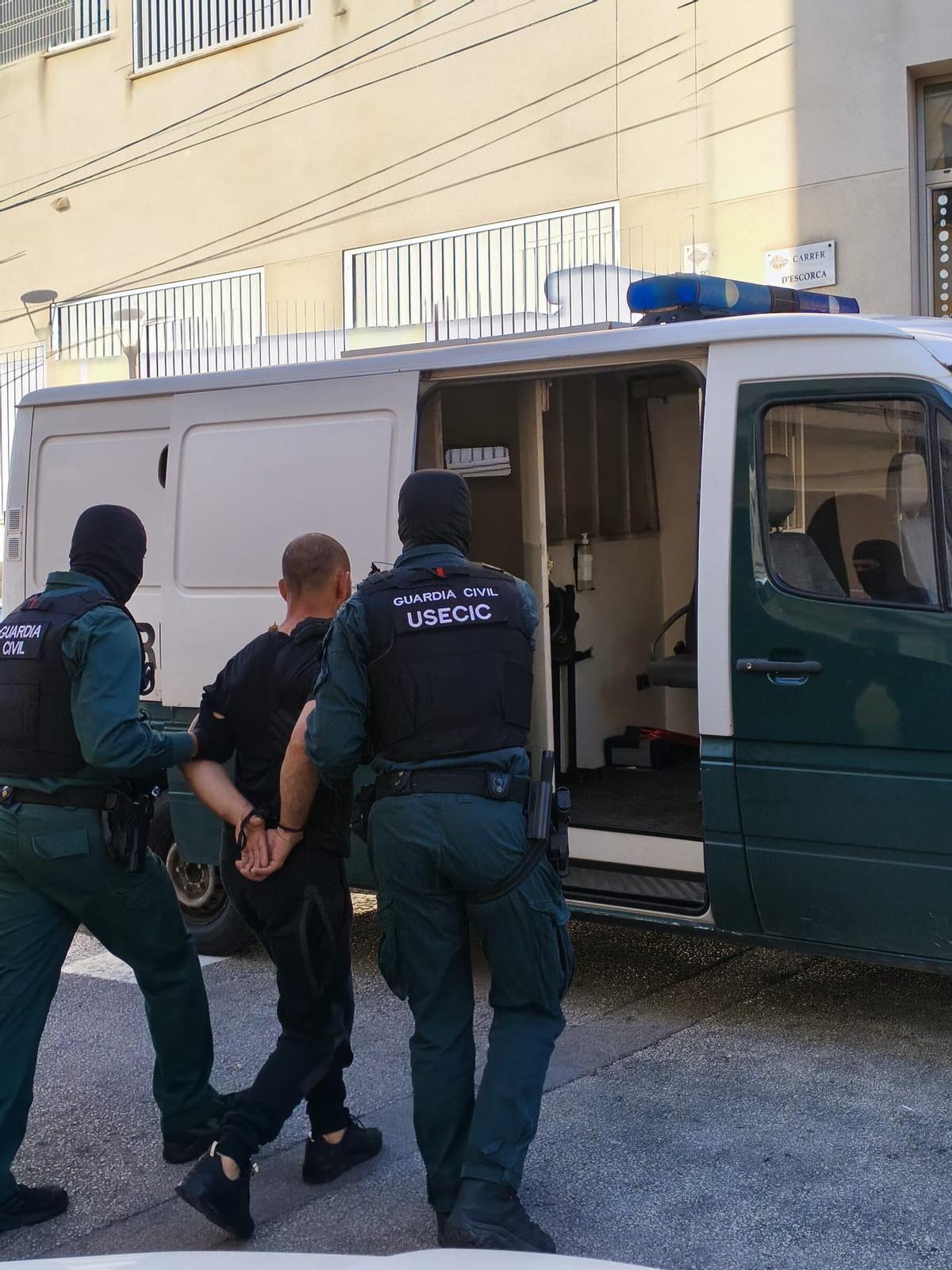 Agentes de la USECIC de la Guardia Civil introducen en el furgón a un detenido en el 'narcopiso' de Inca.