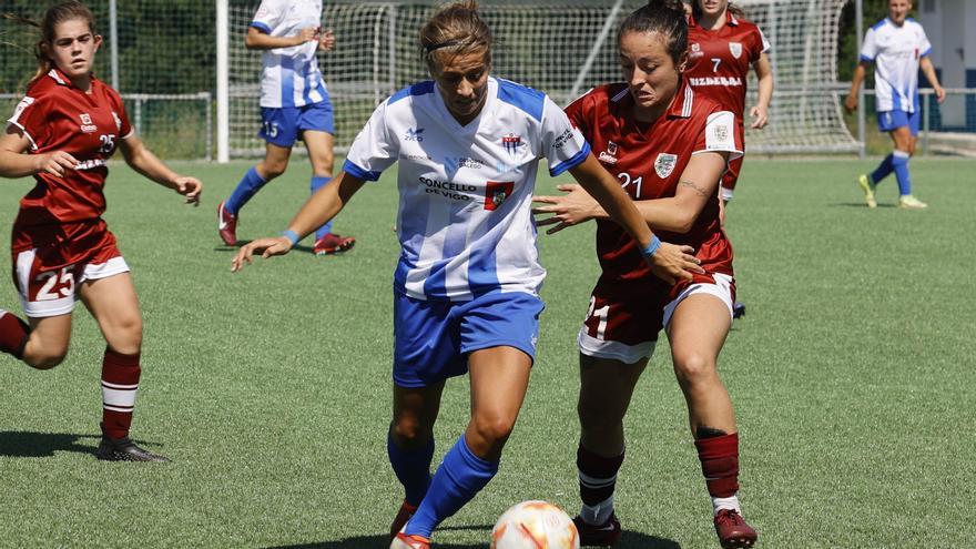 Nerea conduce el balón, ante la presión de Paula Núñez.