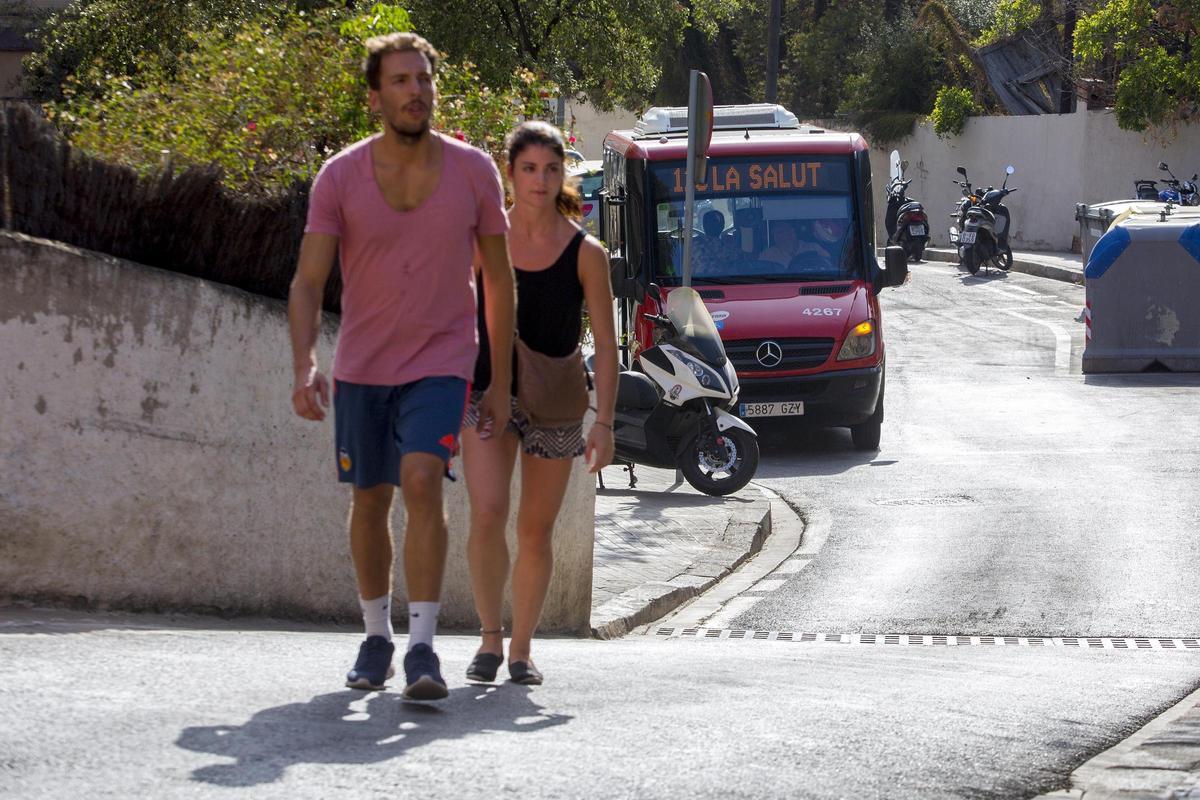 Un par de turistas andan camino del Park Güell, con el 116 a sus espaldas, en agosto de 2016