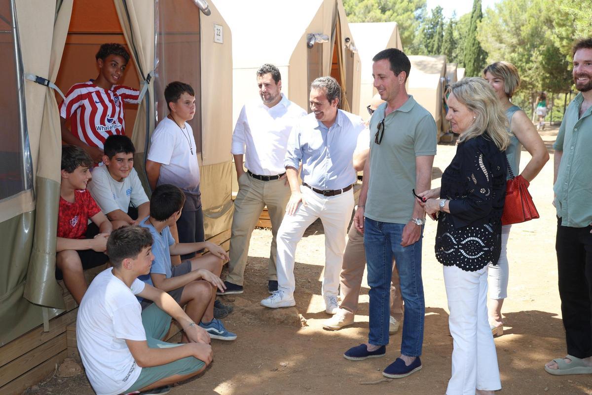La autoridades insulares charlan con algunos niños en el campamento.