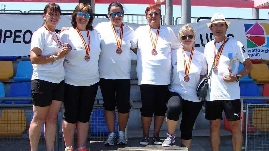 El equipo femenino de compuesto posa con el bronce en el podio de Alcobendas.