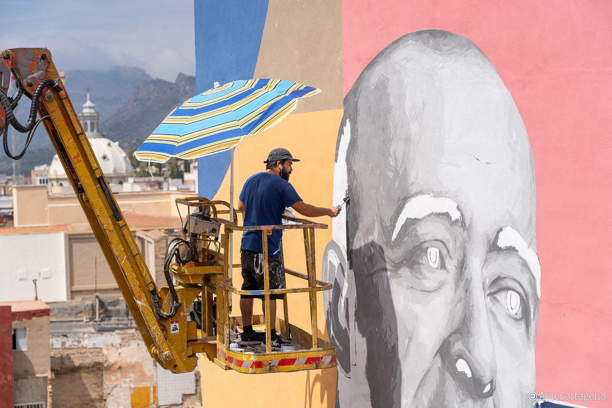 Un grafitero trabajando en un mural en Cartagena.