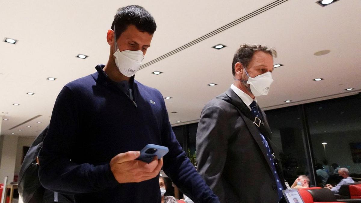 Novak Djokovic mira el telèfon mòbil a l’aeroport de Melbourne | LOREN ELLIOTT/REUTERS