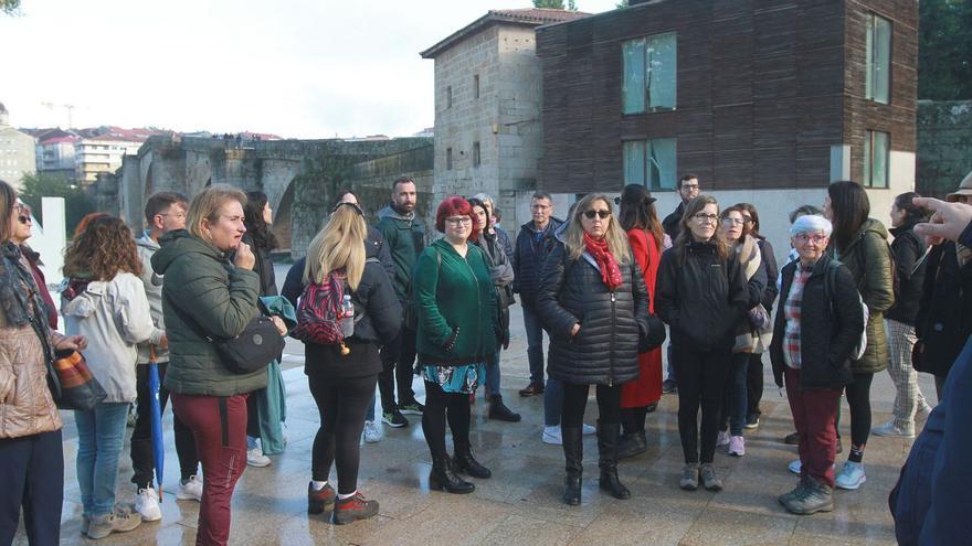 Grupo de turistas en una visita guiada al Puente Romano de Ourense. |   // IÑAKI OSORIO