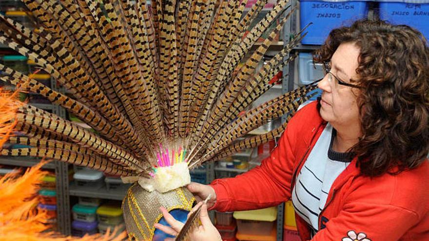 Una de las amigas de Trinidad Prado, ayer, en su taller, con un casquete de plumas. / víctor echave
