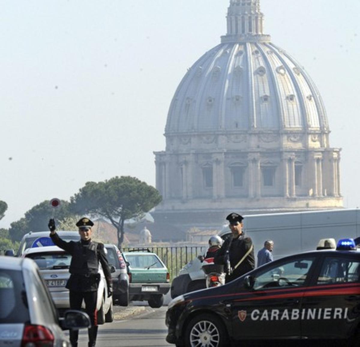 Policies italians fan controls als vehicles que circulen per un carrer pròxim al Vaticà, dijous.