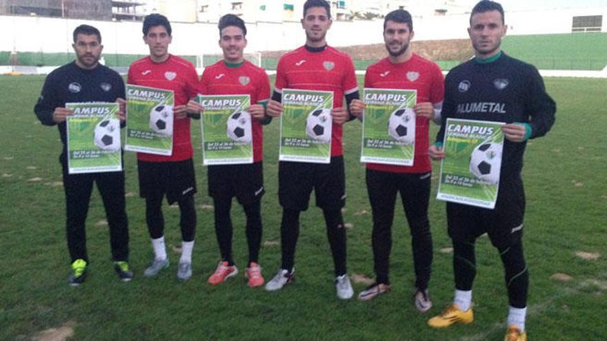 Varios jugadores del Antequera CF, con el cartel del campus.