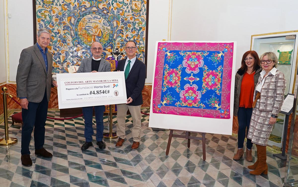 Foto de la donación del primer cheque, junto al nuevo pañuelo.