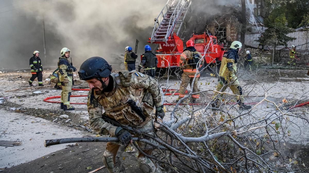 Bomberos y militares ucranianos, en uno de los puntos de Kiev bombardeados por Rusia este lunes.