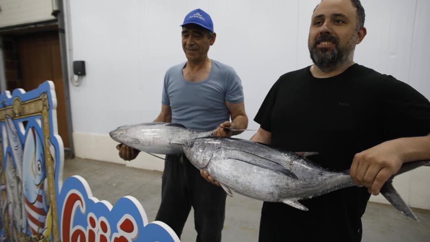 Por la izquierda, Juan Carlos García Suárez y Alexis Suárez Sainz, sostienen dos de los bonitos subastados al mayor precio hoy en El Musel. ANGEL GONZALEZ