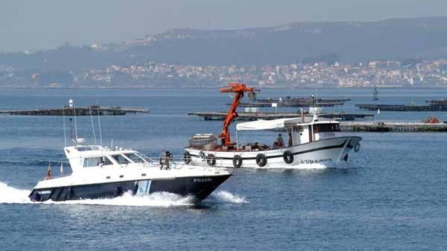 Un barco de vigilancia y una embarcación mejillonera en aguas de Arousa.