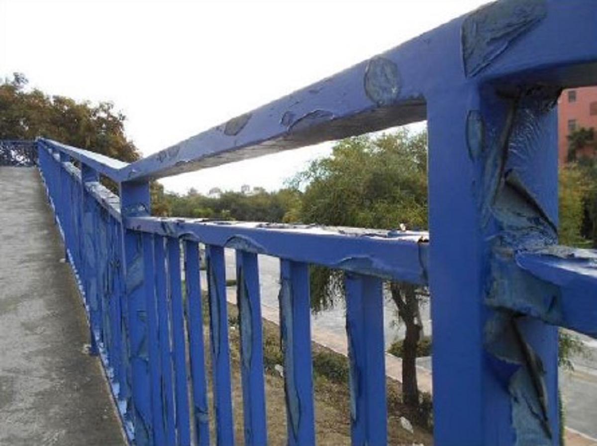 Desperfectos en la barandilla de una pasarela sobre la A-7.