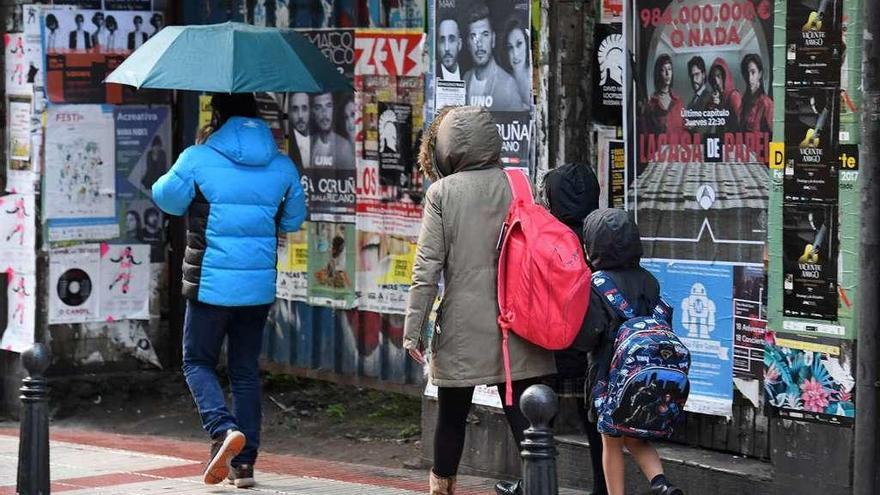 Viandantes se protegen del frío y la lluvia, ayer en A Coruña.