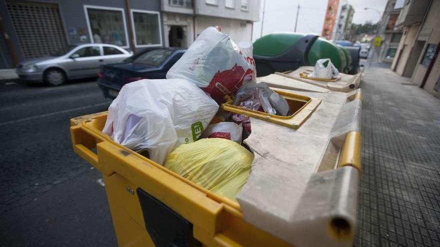 Imagen actual de un contenedor amarillo, lleno y roto, en la avenida de Santiago. // Bernabé/Cris M.V.