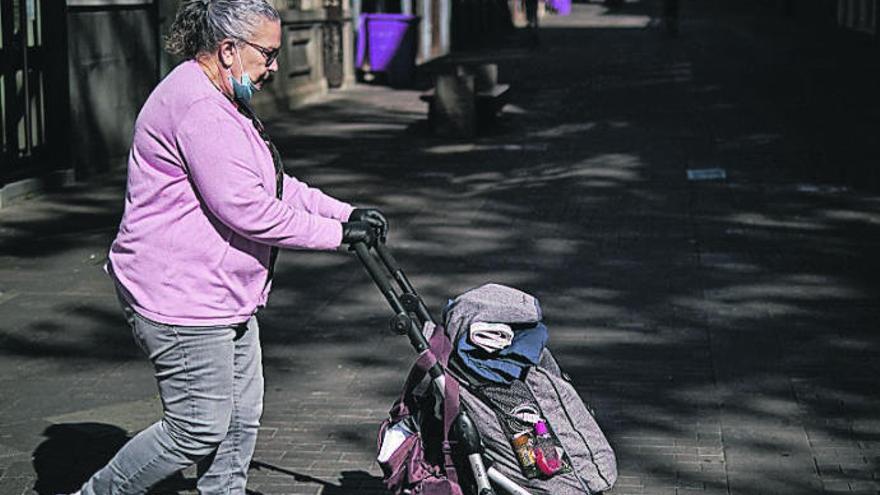 Una vecina de La Laguna atraviesa una vía con un carrito de la compra.